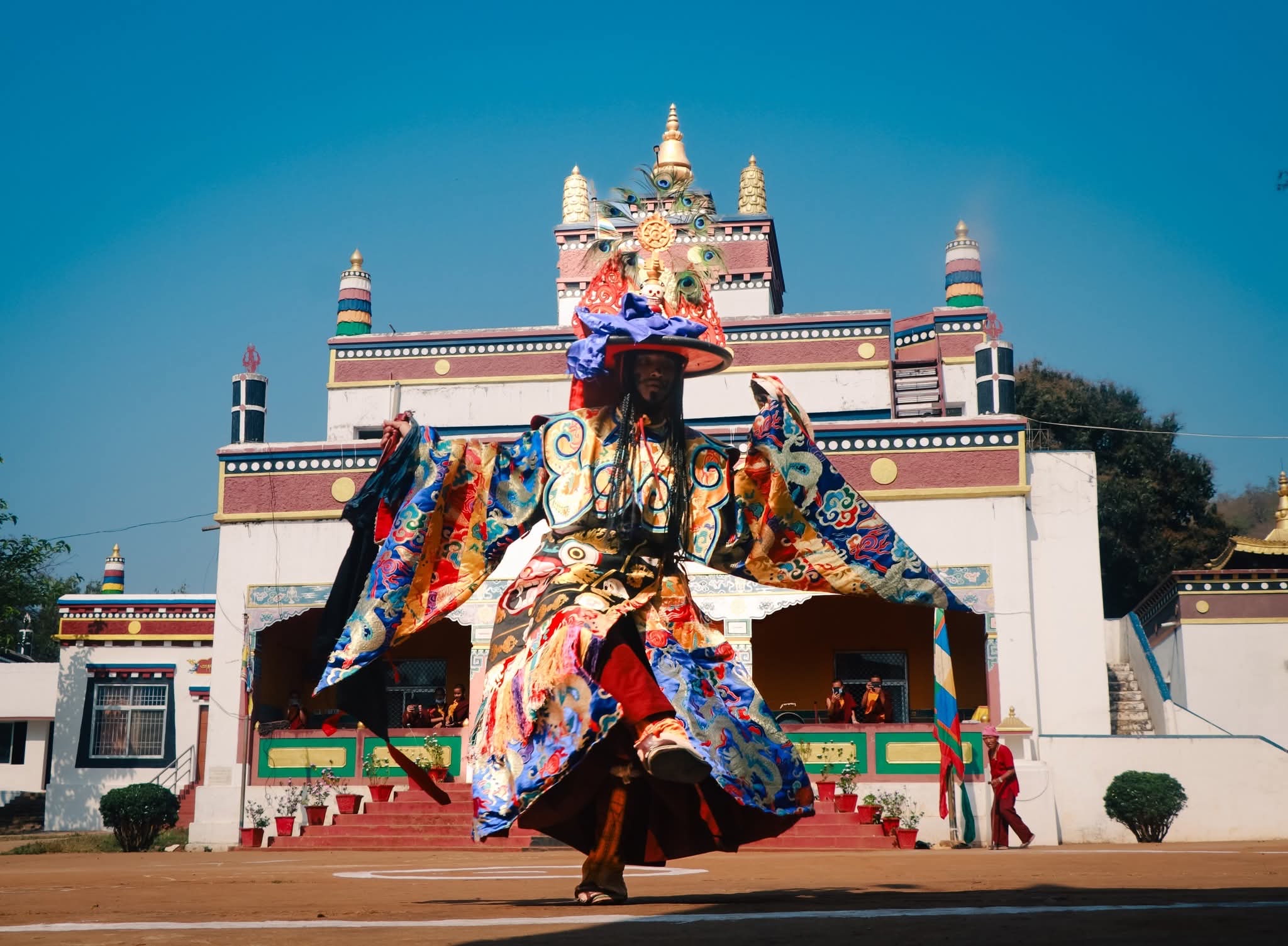 A masked cham dancer in front of the monastery temple