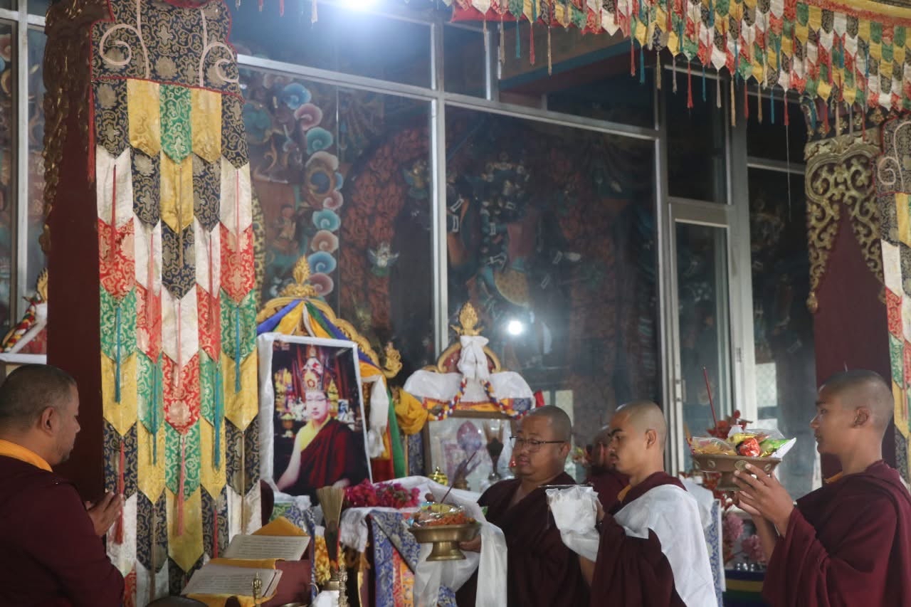 Monks making offerings at the shrine during a puja